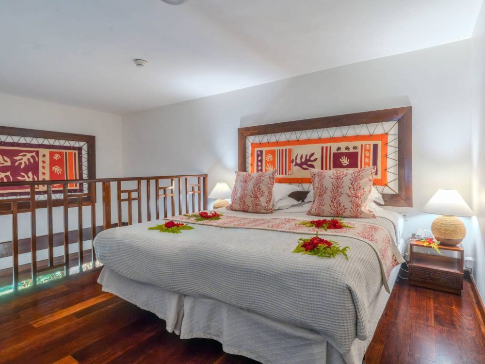 Mezzanine bedroom of the Family Garden Duplex at Manava Beach Resort Moorea featuring a large king-size bed.