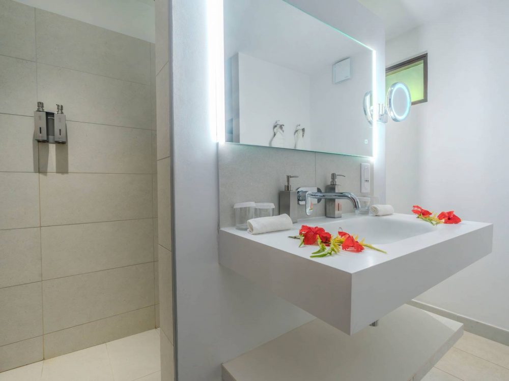 Modern bathroom of the Family Garden Duplex at Manava Beach Resort Moorea featuring a sink and a walk-in shower.