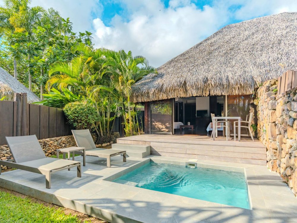 Private wooden terrace of a Garden Bungalow at Manava Beach Resort Moorea furnished with a table, two chairs, and bordering the private pool.